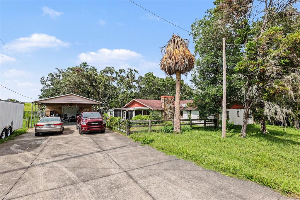 A red pickup truck and a silver sedan are parked on a concrete driveway before a house — 4611 W OLD CITRUS ROAD, LECANTO, FL