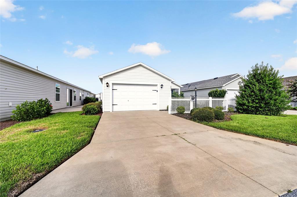 A white single-story house with a two-car garage and a concrete driveway — 5844 MARSH COURT, THE VILLAGES, FL