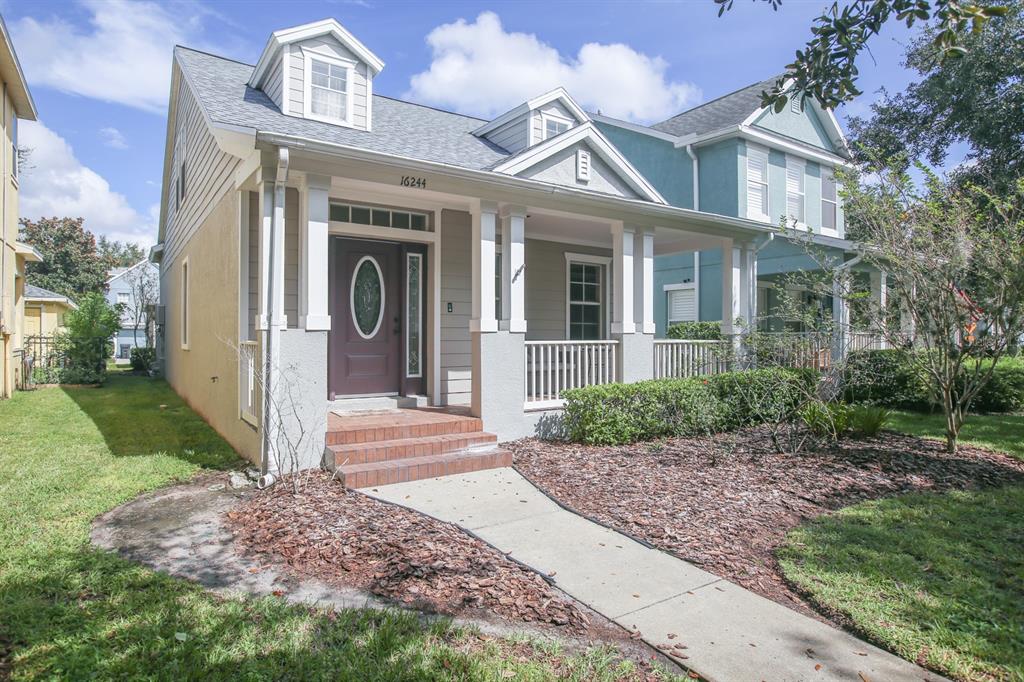 A two-story house with a front porch, dormer windows, and a brick-stepped entryway — 16244 BRIDGEWALK DRIVE, LITHIA, FL