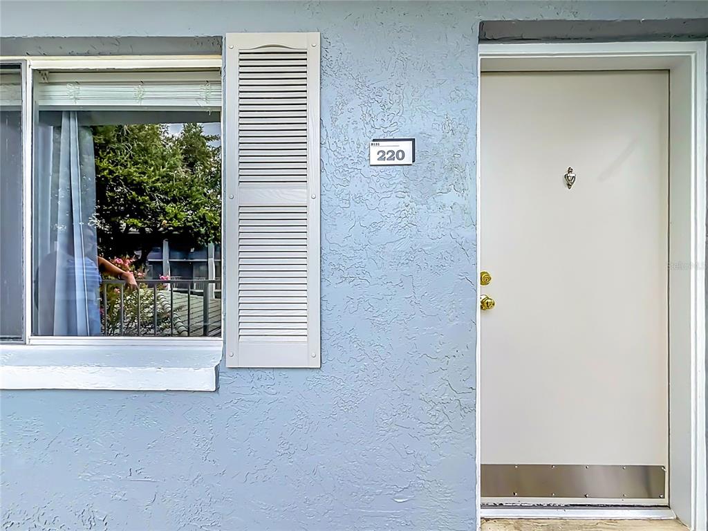 The exterior view shows a light blue wall with a window, a shutter, and a door — 131 WATER FRONT WAY UNIT 220, ALTAMONTE SPRINGS, FL