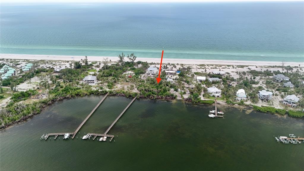 An aerial view of a coastal property featuring a wooden dock extending into the water — 9144 CARTER ST, PLACIDA, FL