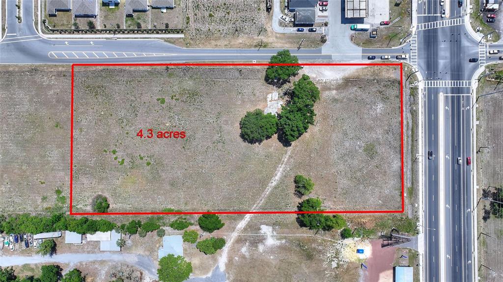 An aerial view shows a rectangular 4.3-acre vacant lot bordered by roads and trees — 75 SAGE ROAD, WINTER HAVEN, FL