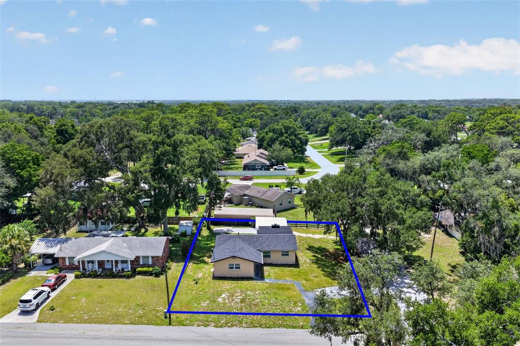 A tan, single-story house with a dark shingled roof sits on a grassy lot — 708 CINDY AVENUE, FRUITLAND PARK, FL