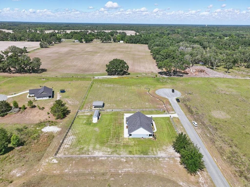 An aerial view shows a house with a fenced yard, a shed, and surrounding fields — 10172 98TH PATH, LIVE OAK, FL