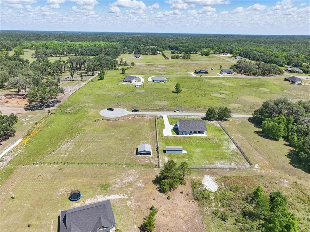 An aerial view shows a single-family home with a fenced yard and outbuildings in a rural area — 10172 98TH PATH, LIVE OAK, FL