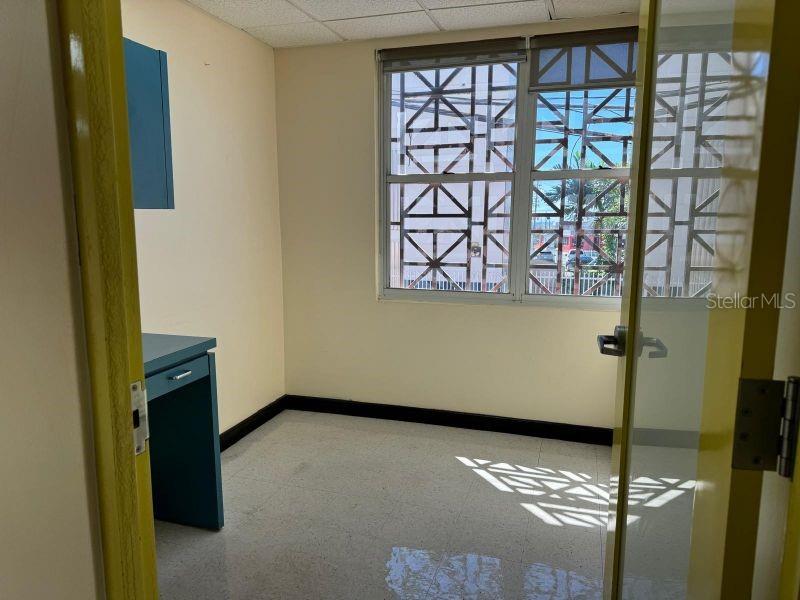 An empty office room features a desk, light-colored walls, tiled floors, and a window — Suite 105 SUITE 105 AGUADILLA MEDICAL PLAZA CONDOMINIUM, AGUADILLA, PR