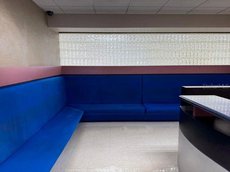 A waiting area features blue bench seating against a wall with glass block windows — Suite 105 SUITE 105 AGUADILLA MEDICAL PLAZA CONDOMINIUM, AGUADILLA, PR