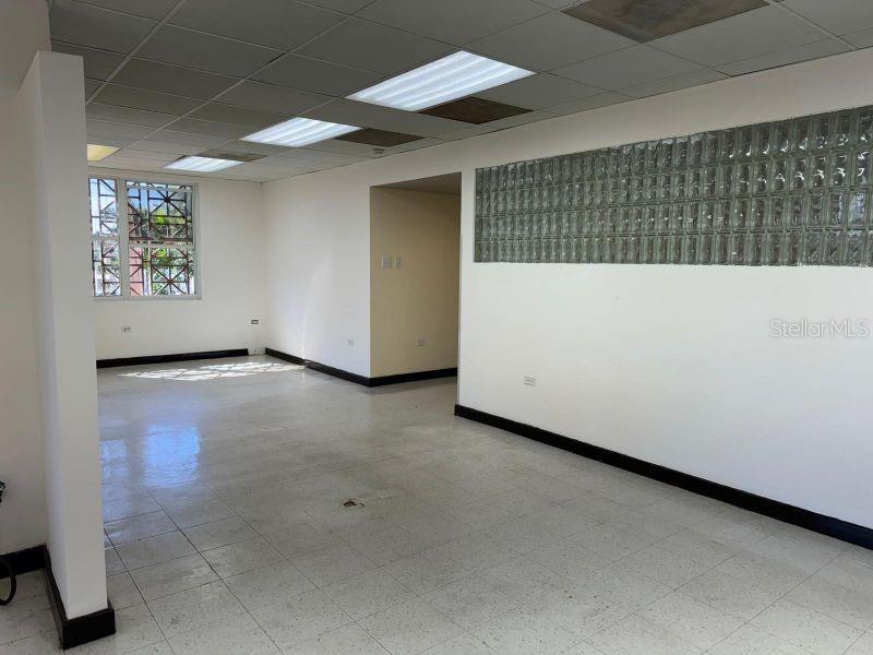 An empty office space features a glass block wall, white walls, and tiled flooring — Suite 105 SUITE 105 AGUADILLA MEDICAL PLAZA CONDOMINIUM, AGUADILLA, PR