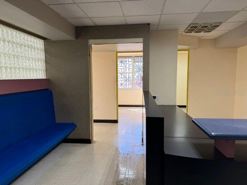 An office interior features a blue bench, a dark reception desk, and a glass block wall — Suite 105 SUITE 105 AGUADILLA MEDICAL PLAZA CONDOMINIUM, AGUADILLA, PR