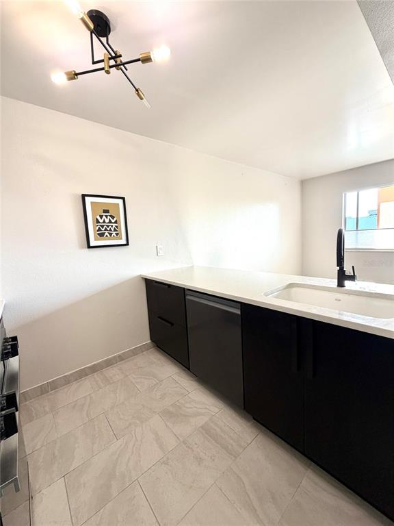 A kitchen with dark cabinets and light tile flooring opens into a living area — 2525 W BAY DRIVE UNIT C34, LARGO, FL