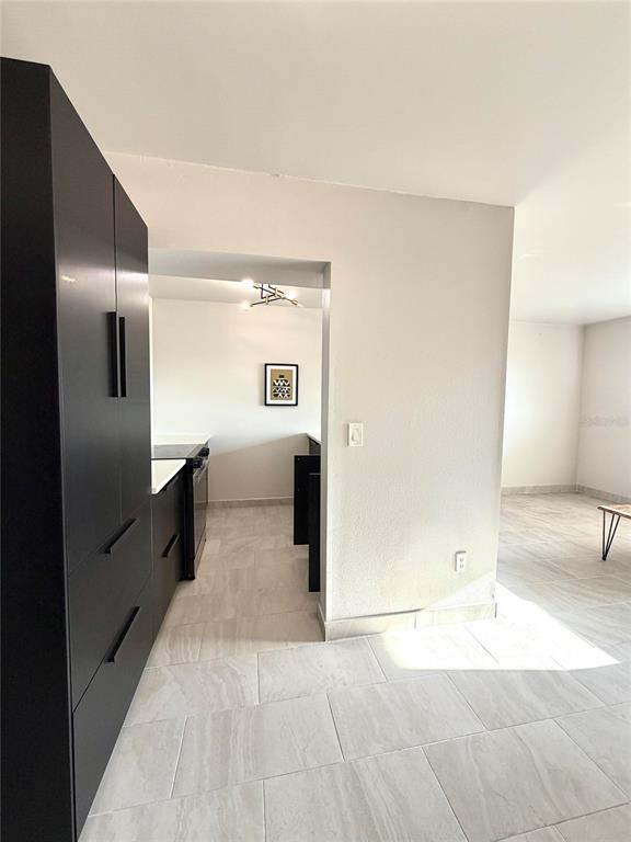 An empty room with light-colored tile flooring and a large window overlooking trees — 2525 W BAY DRIVE UNIT C34, LARGO, FL