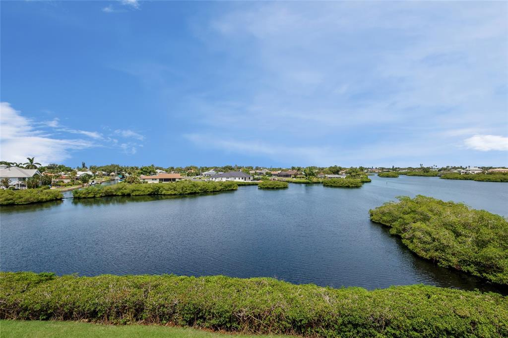 A view of a calm waterway surrounded by lush mangrove islands and residential homes — 5100 JESSIE HARBOR DRIVE UNIT 404, OSPREY, FL