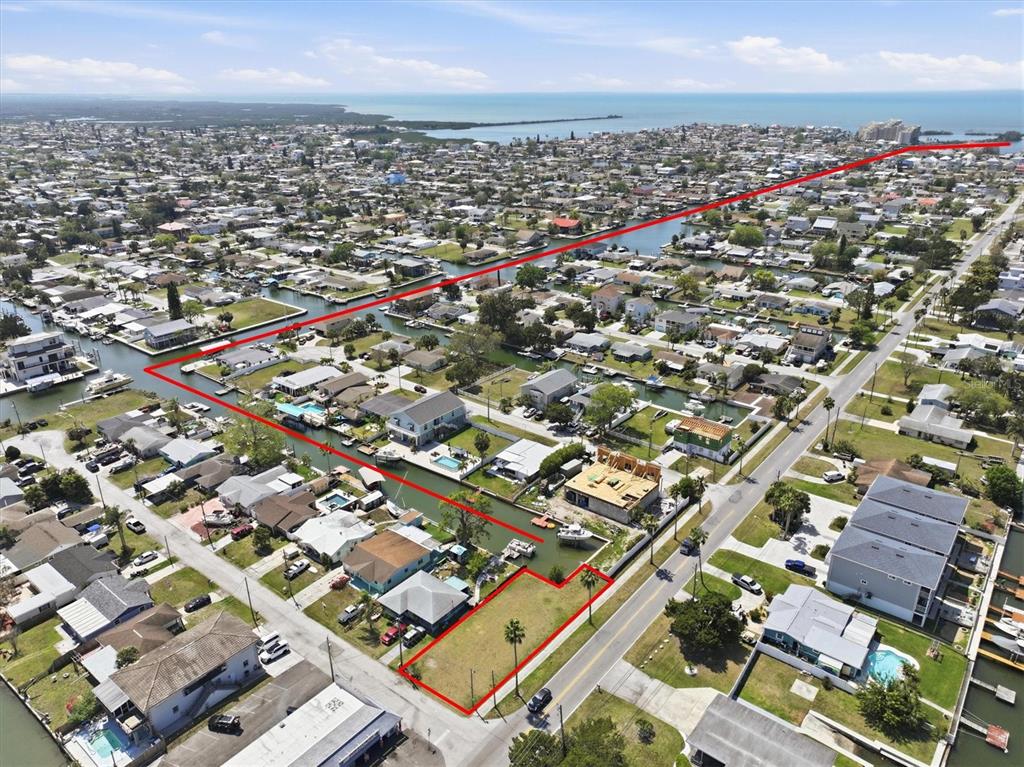 An aerial view shows a vacant waterfront lot outlined in red within a residential neighborhood — 13939 MURIEL DRIVE, HUDSON, FL