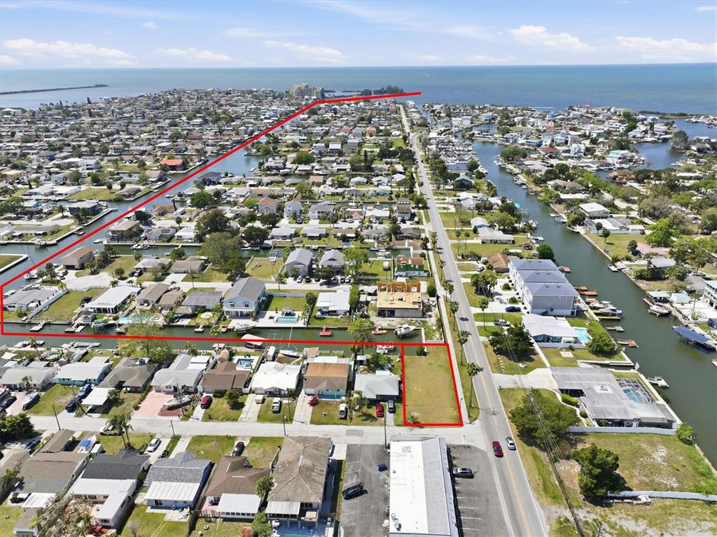 An aerial view shows a vacant lot and residential properties along a canal — 13939 MURIEL DRIVE, HUDSON, FL