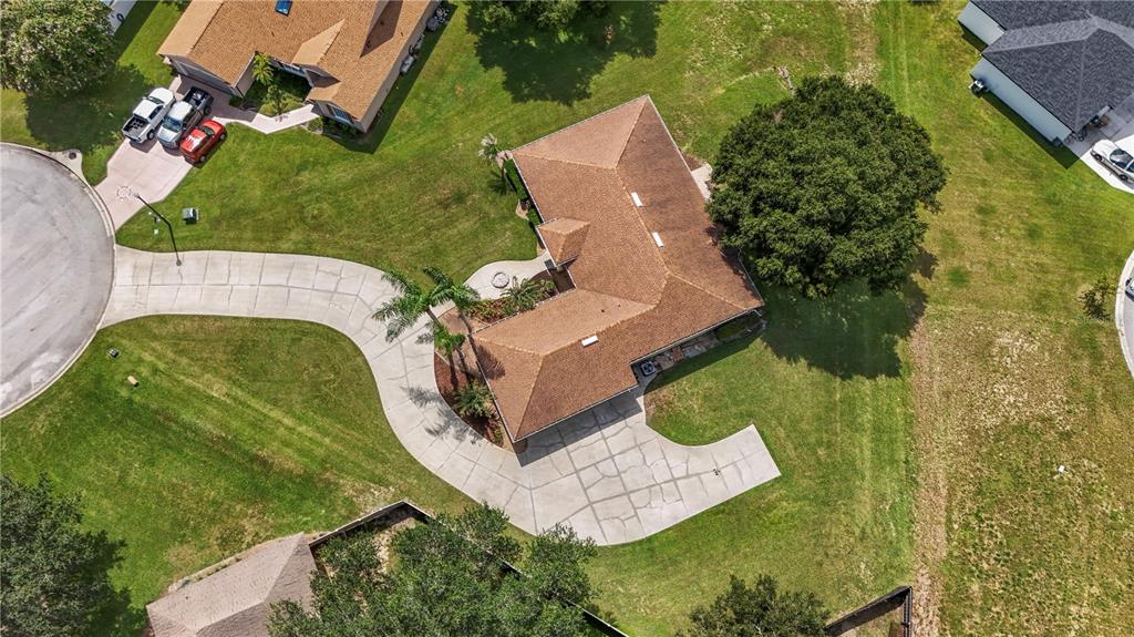 An aerial view shows a house with a brown roof, large driveway, and surrounding lawn — 11546 NICE COURT, CLERMONT, FL