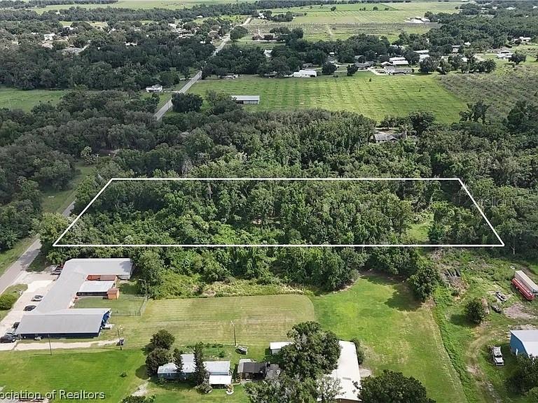 An aerial view shows a rectangular plot of land outlined in white amidst wooded surroundings — HANCHEY ROAD, WAUCHULA, FL
