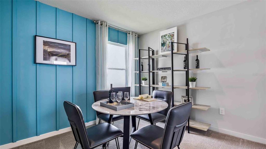 A dining room features a blue accent wall, a round marble table, and open shelving — 18227 BEEHIVE TERRACE, LAKEWOOD RANCH, FL
