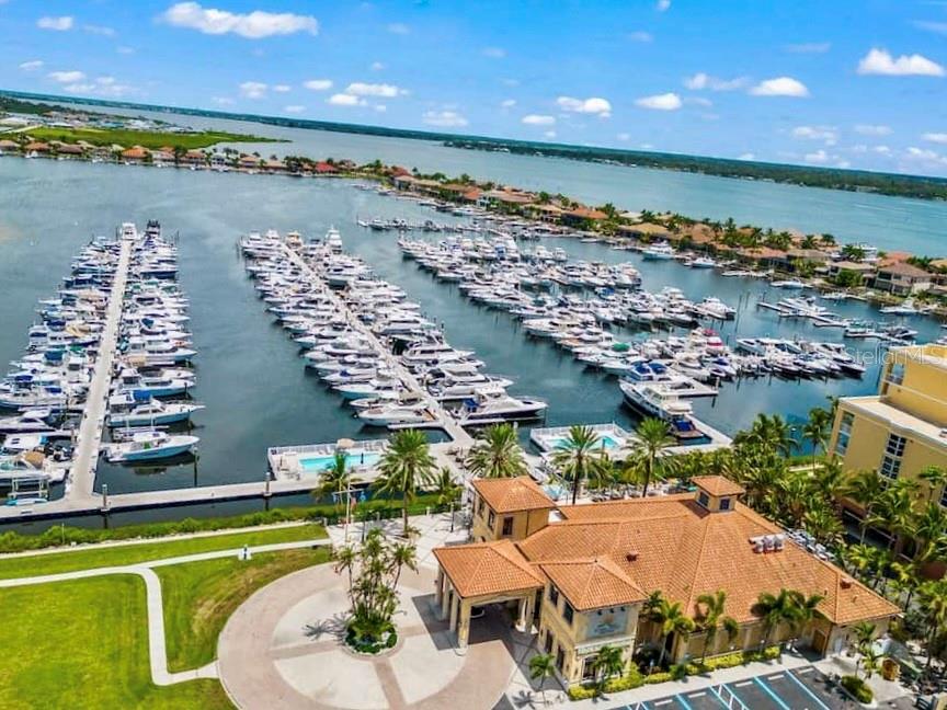 A rectangular swimming pool sits on a deck overlooking a marina filled with boats — 102 RIVIERA DUNES WAY UNIT C10, PALMETTO, FL