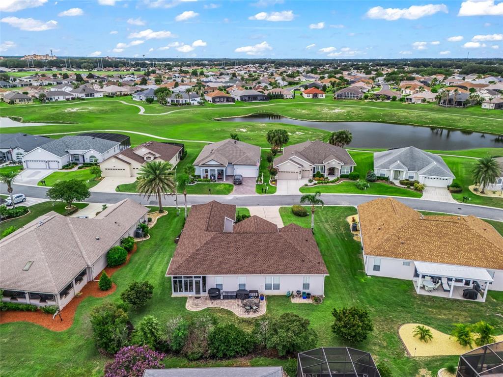 An aerial view shows a suburban neighborhood with houses, a golf course, and a pond — 12421 SE 174TH LOOP, SUMMERFIELD, FL