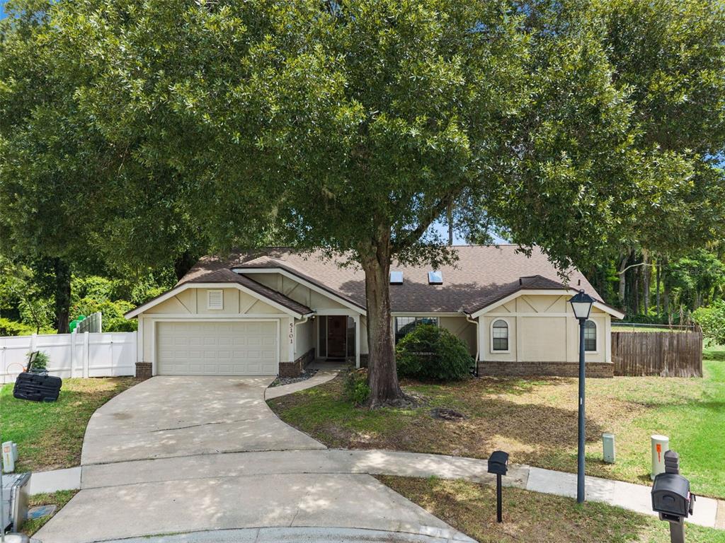 A single-story house with a beige exterior, a two-car garage, and a large front tree — 5101 GOLDENWOOD DRIVE, ORLANDO, FL