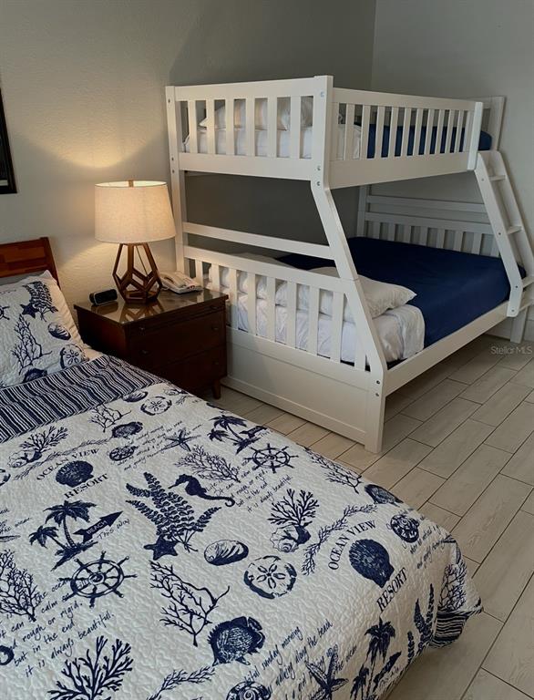 A bedroom features a twin-over-full bunk bed and a separate bed with nautical-themed bedding — 7150 N TAMIAMI TRAIL UNIT N420, SARASOTA, FL