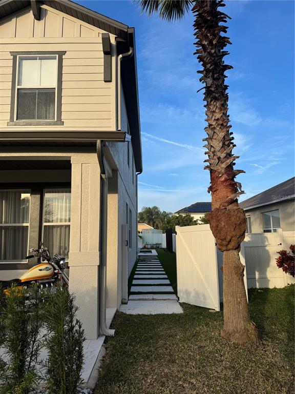 The exterior of a two-story house features a side walkway, a palm tree, and a motorcycle — 526 FIRST CAPE CORAL DRIVE, WINTER GARDEN, FL