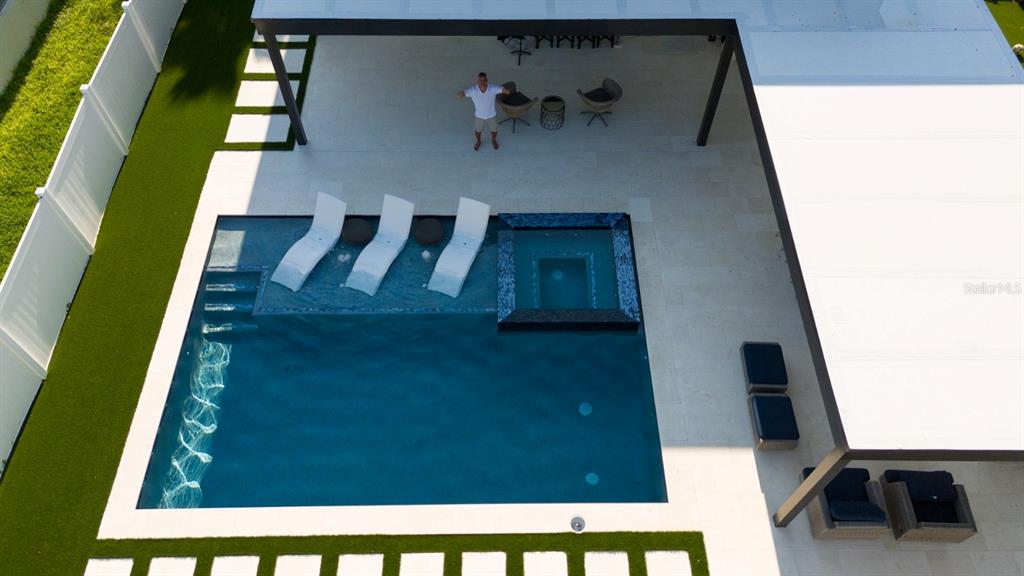 An aerial view shows a swimming pool with a spa and lounge chairs on a patio — 526 FIRST CAPE CORAL DRIVE, WINTER GARDEN, FL