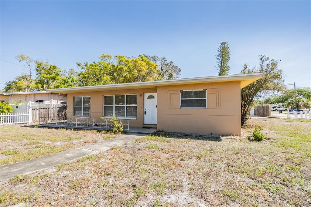 A single-story tan house with a white front door and a concrete walkway — 5130 DR MARTIN LUTHER KING JR ST S, ST PETERSBURG, FL