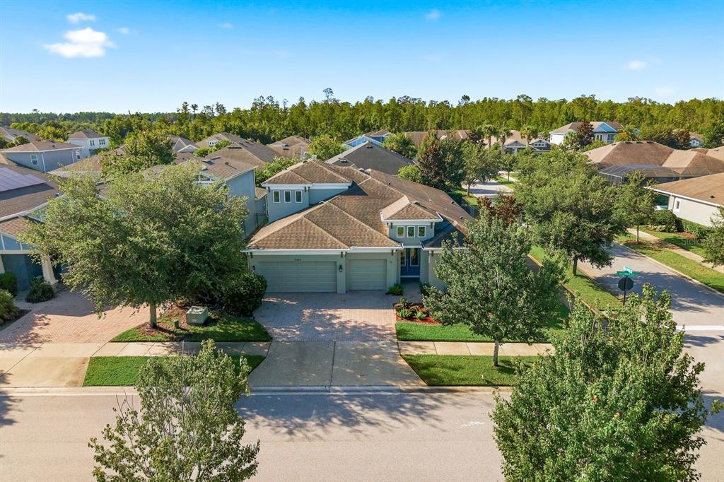 An aerial view of a suburban house with a two-car garage and a paved driveway — 16485 COURTYARD LOOP, LAND O LAKES, FL