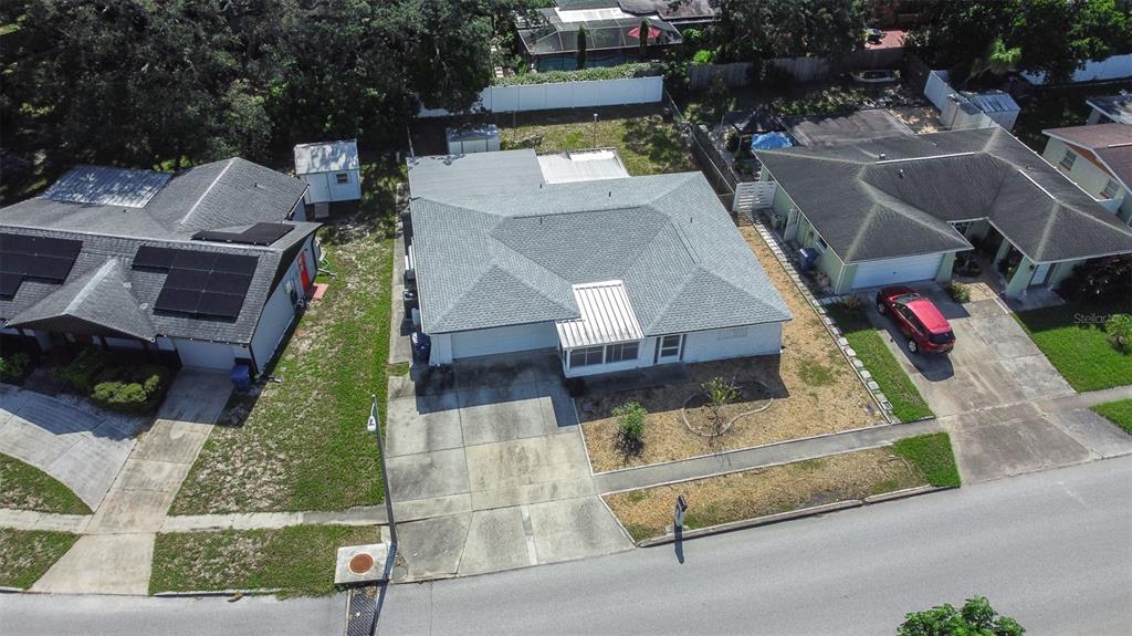 An aerial view shows a suburban house with a gray roof and a concrete driveway — 4636 ACKERMAN STREET, NEW PORT RICHEY, FL