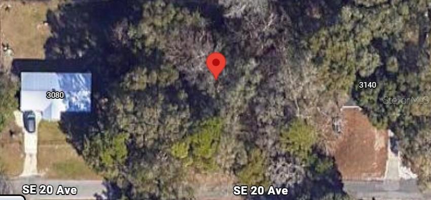 This aerial map shows a vacant, wooded lot situated between two residential properties — 3090 SE 20TH AVENUE, GAINESVILLE, FL