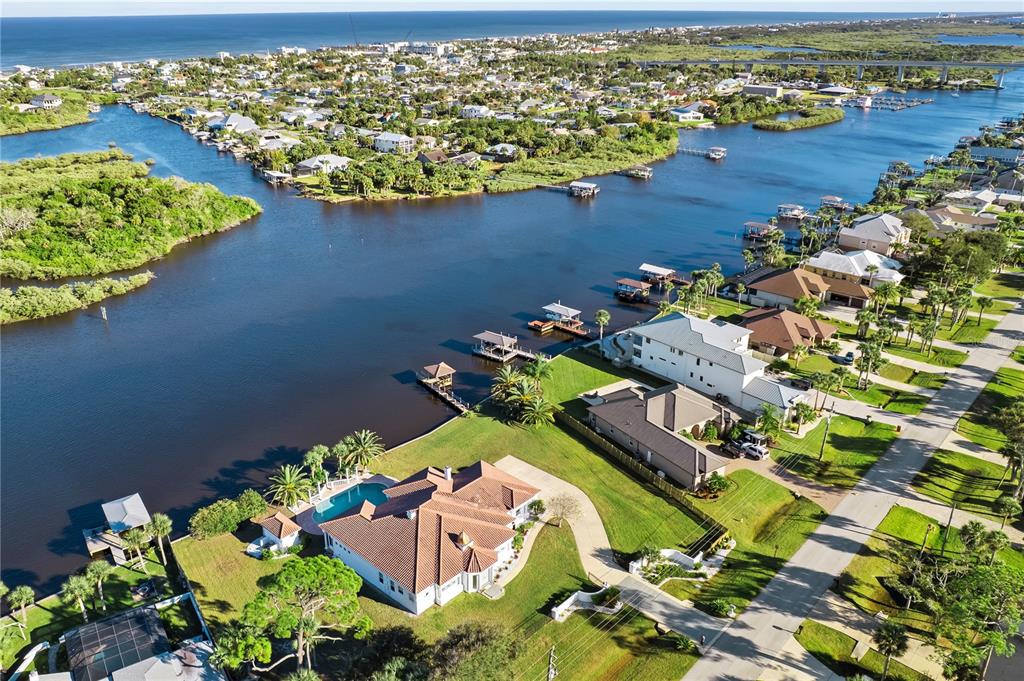 An aerial view shows waterfront houses with private docks along a canal near the ocean — 660 LAMBERT AVENUE, FLAGLER BEACH, FL