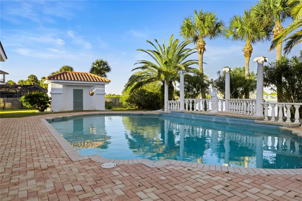 A swimming pool with a patio, lounge chairs, and a small white pool house — 660 LAMBERT AVENUE, FLAGLER BEACH, FL