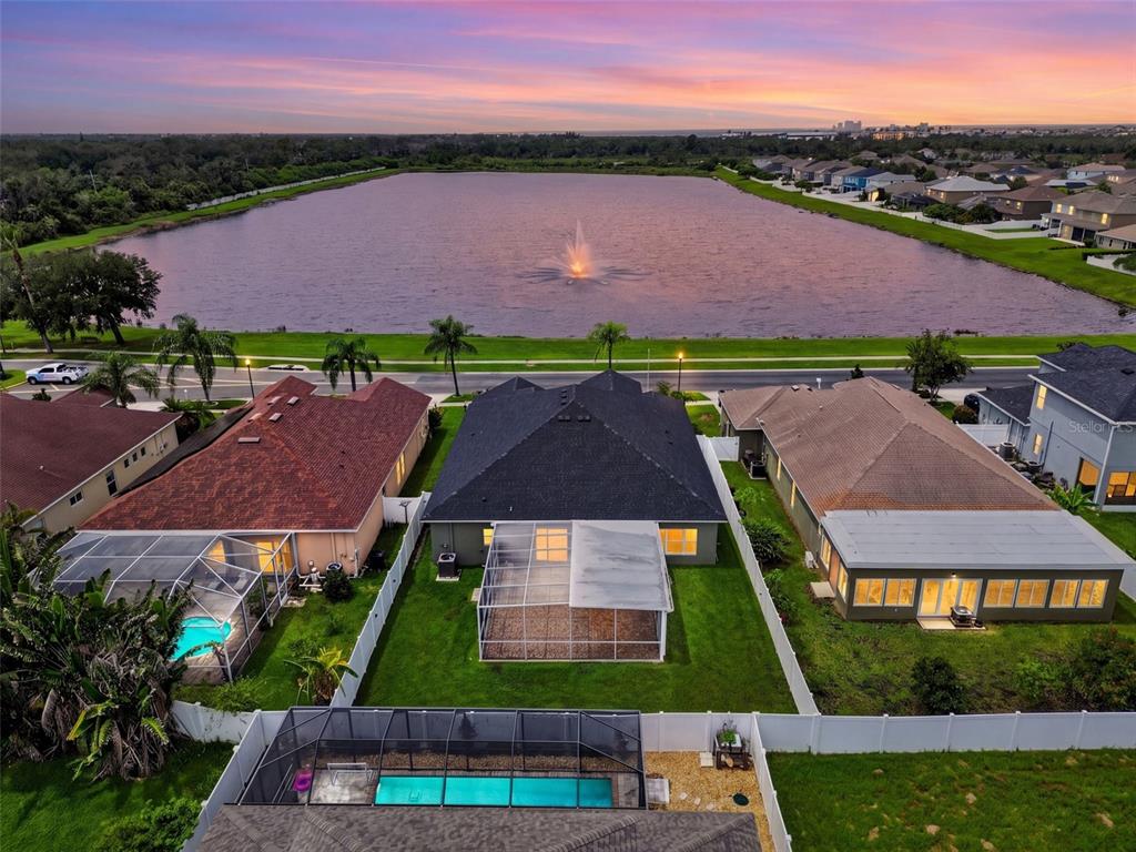 An aerial view of a suburban neighborhood featuring houses with pools overlooking a large lake — 319 19TH STREET NW, RUSKIN, FL