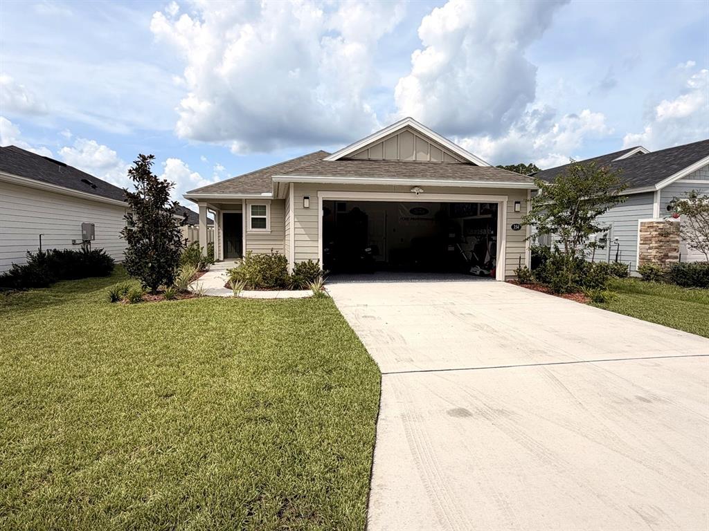 A single-story house with beige siding, a two-car garage, and a concrete driveway — 354 BOULDER LANE, ST JOHNS, FL