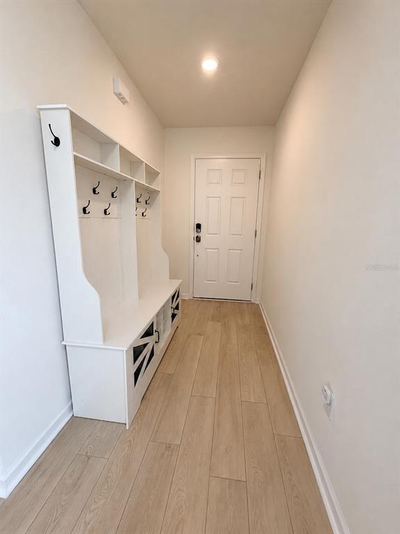 An entryway features a white hall tree with storage and light wood-look flooring — 354 BOULDER LANE, ST JOHNS, FL