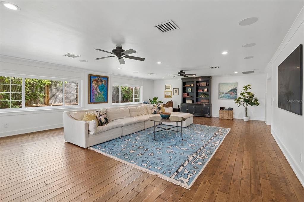 A spacious living room features a large sectional sofa, a blue area rug, and hardwood floors — 2807 W FOUNTAIN BOULEVARD, TAMPA, FL