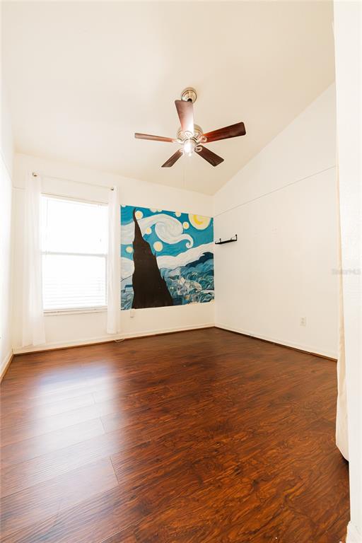 An empty room with dark wood flooring, a ceiling fan, and a mural on the wall — 1844 OXTON COURT, OCOEE, FL
