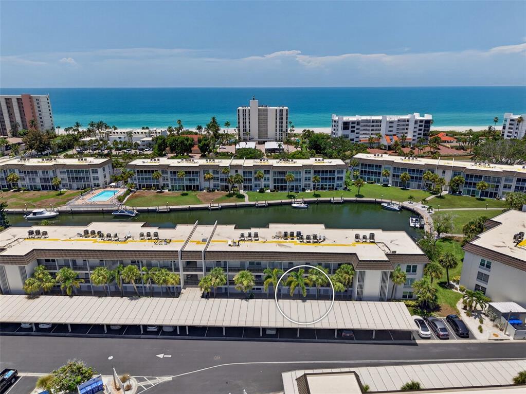 An aerial view of a coastal residential complex at sunset with a nearby beach — 4390 EXETER DRIVE UNIT 107, LONGBOAT KEY, FL