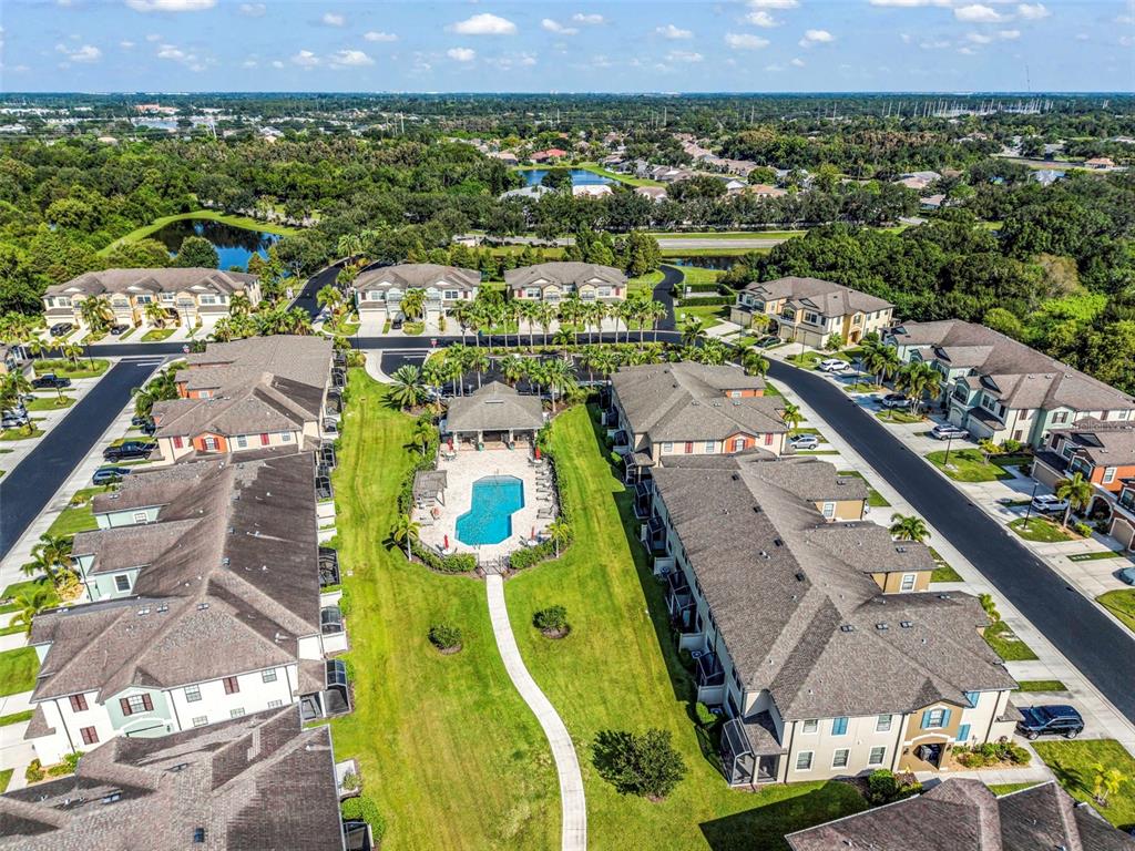 An aerial view of a residential complex featuring multi-story buildings, a central pool, and landscaping — 7826 52ND TERRACE E, BRADENTON, FL