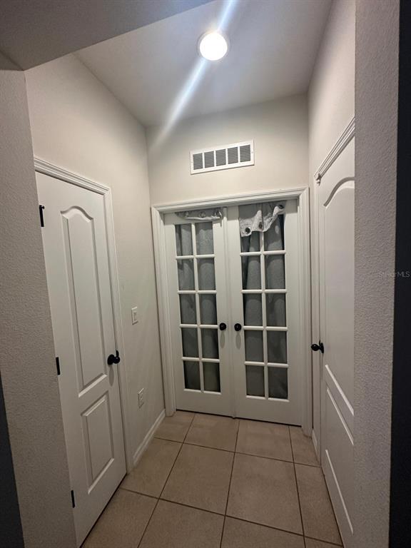 A tiled entryway features two white paneled doors and a set of glass-paned French doors — 1382 RILEY CIRCLE, DELAND, FL