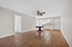A two-story apartment building with beige stucco walls, tan trim, and a concrete walkway — 219 PALMETTO COURT UNIT 219, OLDSMAR, FL