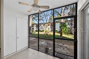A dining area features tan tile flooring, a ceiling fan, and an open kitchen pass-through — 219 PALMETTO COURT UNIT 219, OLDSMAR, FL