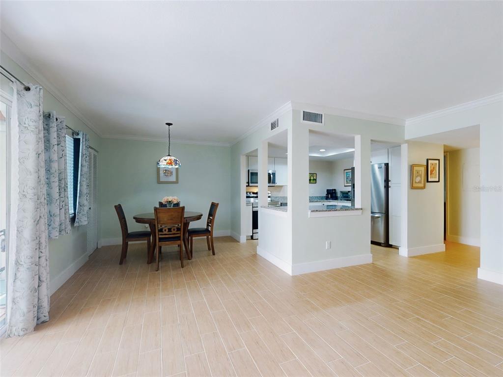 A dining area with a round table and chairs sits adjacent to an open kitchen — 588 BAHIA CIRCLE UNIT A, OCALA, FL