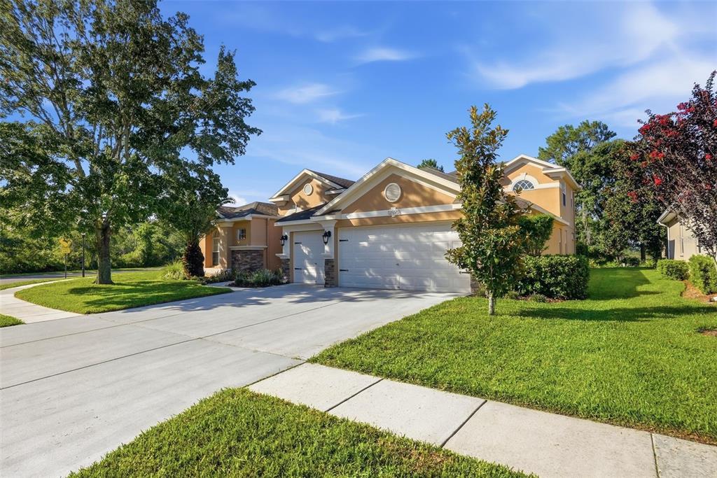 A living room features a stone fireplace, built-in cabinets, arched windows, and a mounted television — 12903 DRAKEFIELD DRIVE, SPRING HILL, FL