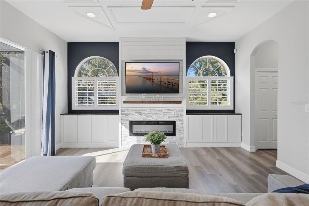 The exterior of a two-story house features a tan stucco facade, arched windows, and a screened-in patio — 12903 DRAKEFIELD DRIVE, SPRING HILL, FL