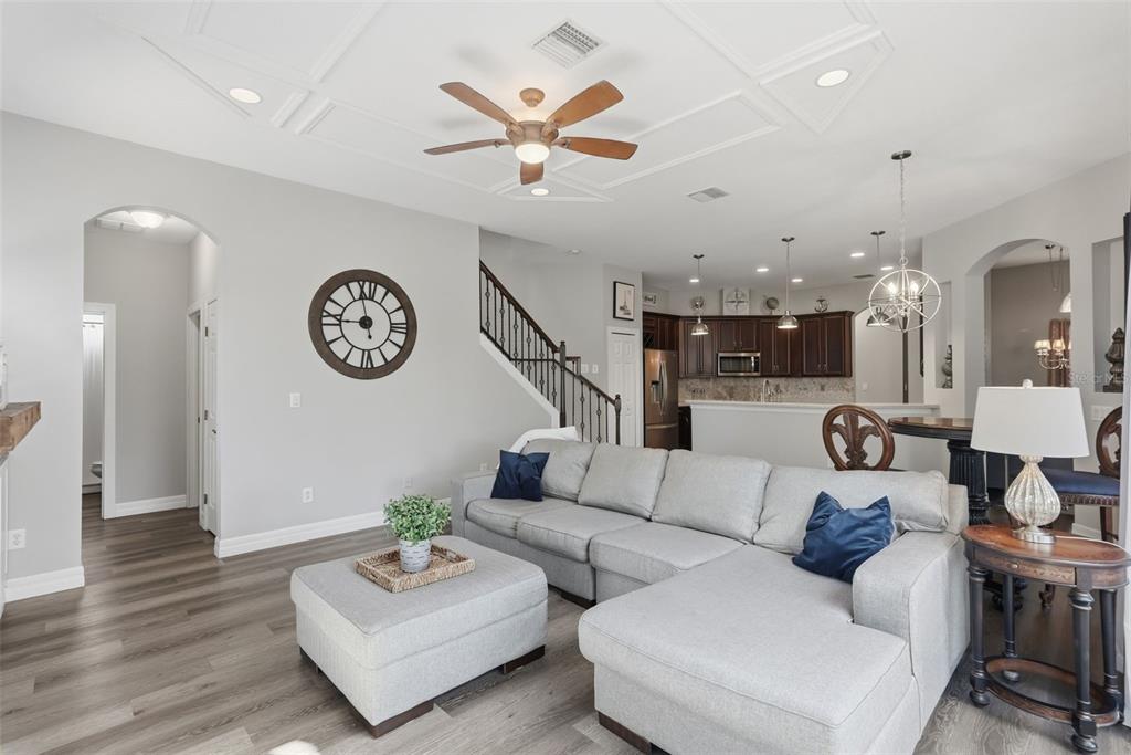 A kitchen with dark wood cabinets, stainless steel appliances, light countertops, and wood-look flooring — 12903 DRAKEFIELD DRIVE, SPRING HILL, FL