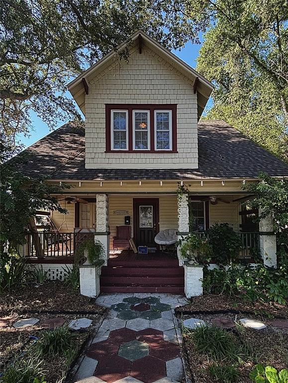 A two-story house with a front porch, shingled siding, and a hexagonal patterned walkway — 427 9TH AVENUE N, ST PETERSBURG, FL