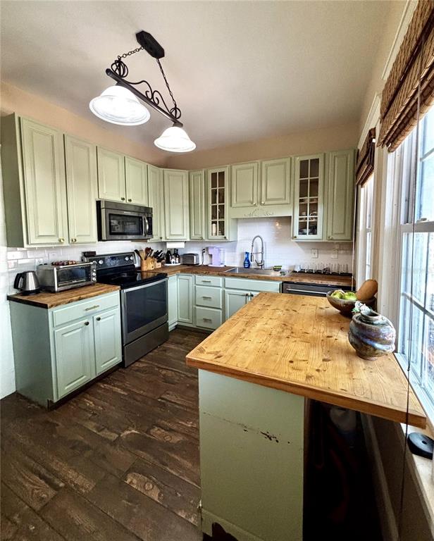 A kitchen features sage green cabinets, wood countertops, and a wood-look tile floor — 427 9TH AVENUE N, ST PETERSBURG, FL