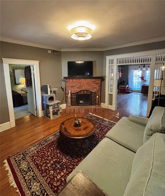A living room features a brick fireplace, hardwood floors, and a light blue sofa — 427 9TH AVENUE N, ST PETERSBURG, FL